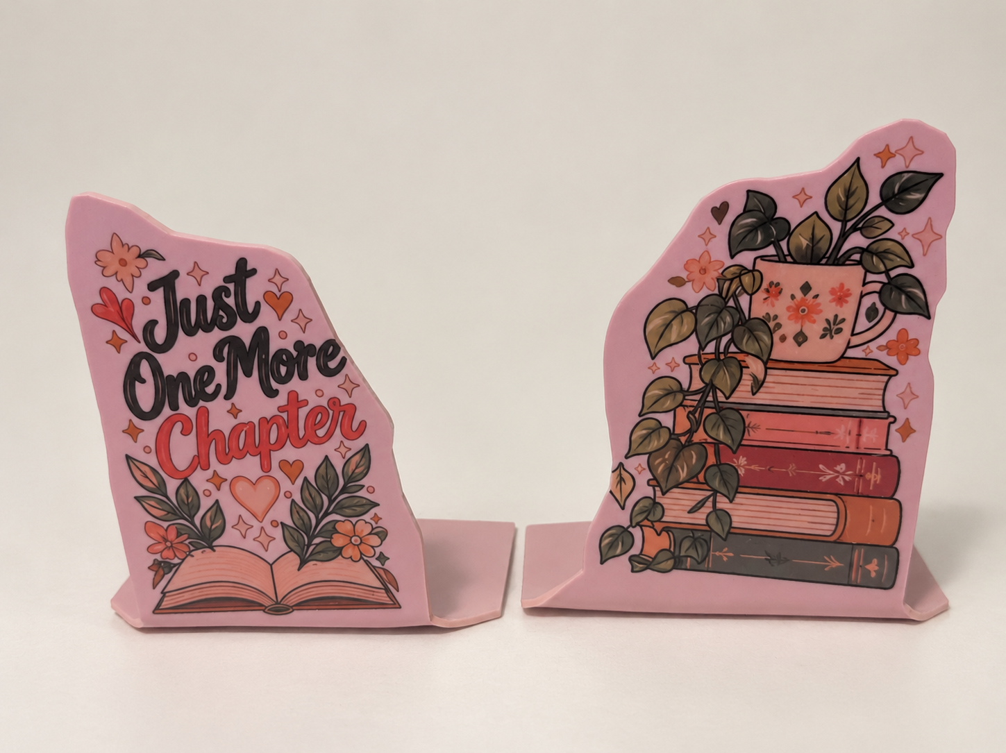 Pink botanical bookend pair with Just One More Chapter lettering and a books-and-plants illustration