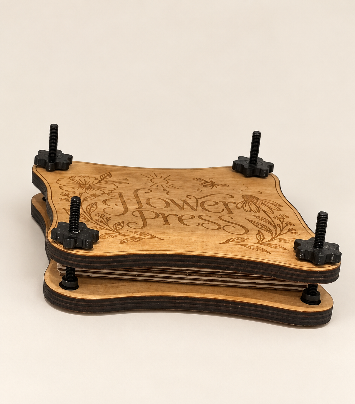 Side view of a wooden flower press showing its layered construction and hand-tightened corner screws